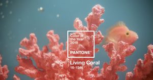 Coral de color coral con un pez color coral dentro de una pecera en fondo azul